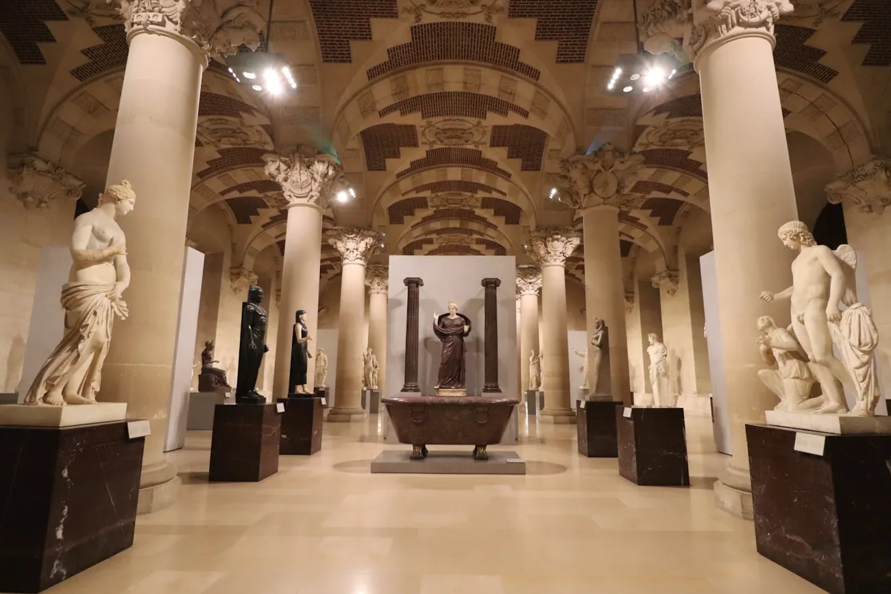 Marmorstatuer på sokler i en stor søylehall i et arkeologisk museum