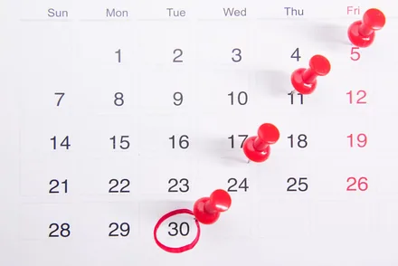 Kalender med røde nåler og dag 30 ringet inn med rødt