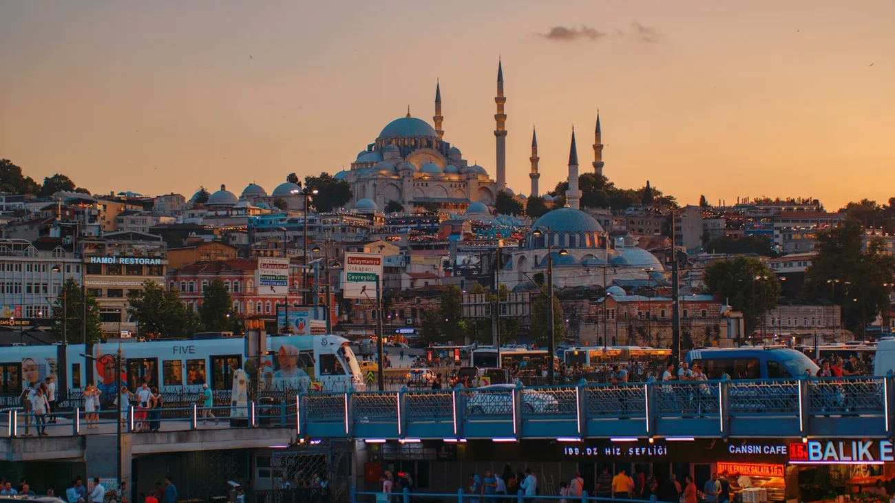 Bysilhuetten i Istanbul med moskeer og minareter mot rødlig kveldshimmel