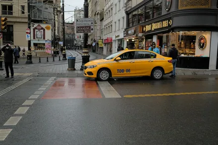 Gul taxi står og venter i et gatekryss med tyrkiske butikkskilt